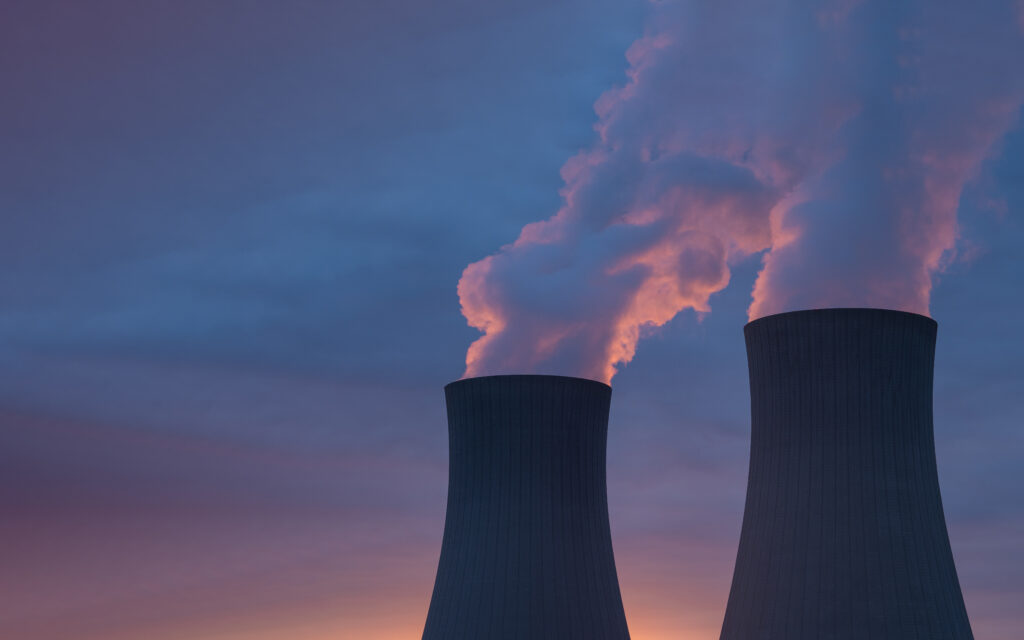 Usina termoelétrica operando ao entardecer, ilustrando o uso de fontes mais caras na geração de energia e como isso contribui para o aumento da conta de luz em períodos de bandeira vermelha.