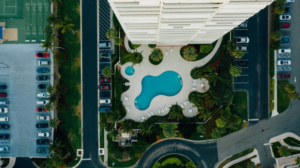Vista aérea de condomínio com piscina e área comum, ideal para energia solar por assinatura